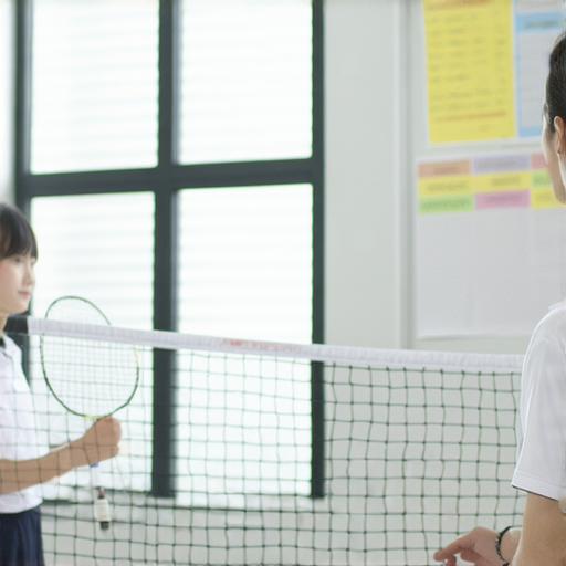 掌握羽球術語的學員與外籍老師一對一上課的場景，學生專心聆聽，提升英文技巧，加強羽球相關詞彙，享受學習的過程，展現積極向上的學習態度。